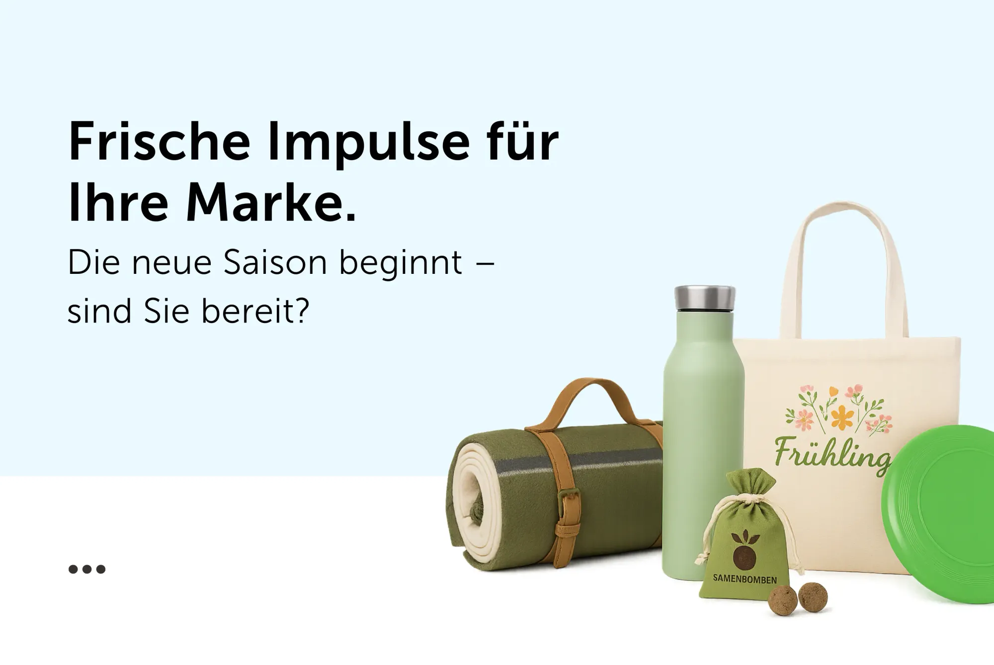 Frühlingshafte Werbeartikel vor weißem Hintergrund: Picknickdecke, Trinkflasche, Samenbomben, Jutetasche und Frisbee.