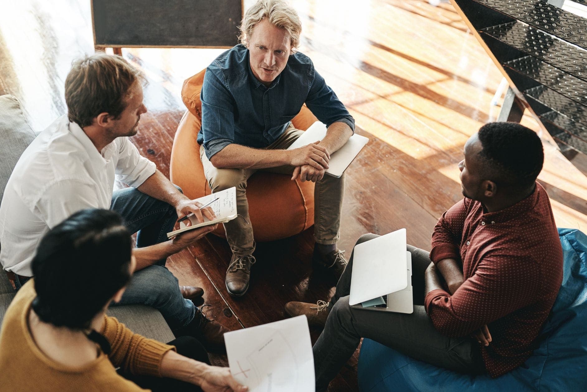 Headerbild Mitarbeiter:innen reden in Kreis miteinander