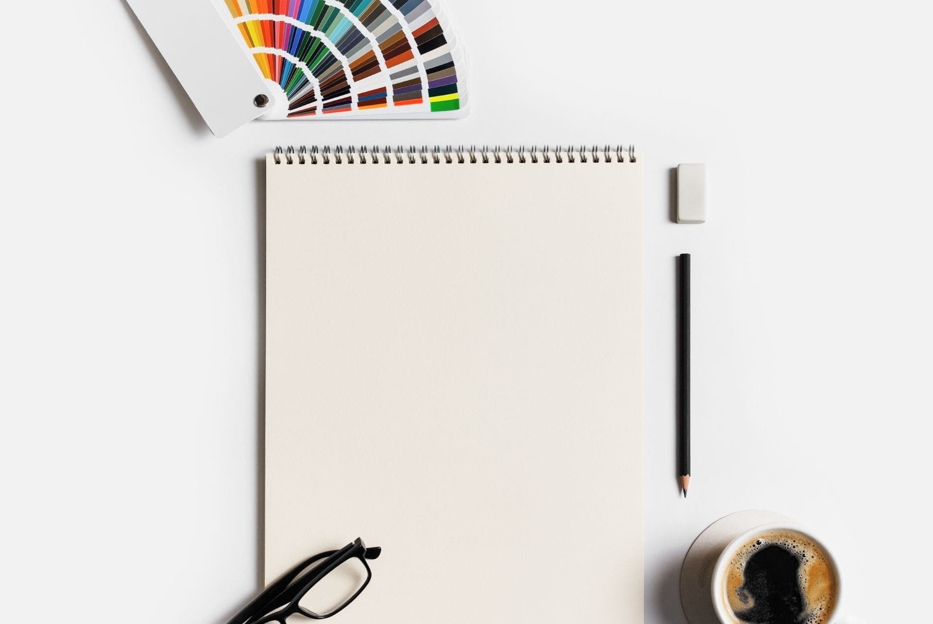 Headerbild Blog mit Farbpalette, Brille, Kaffee, Stift und Radiergummi.