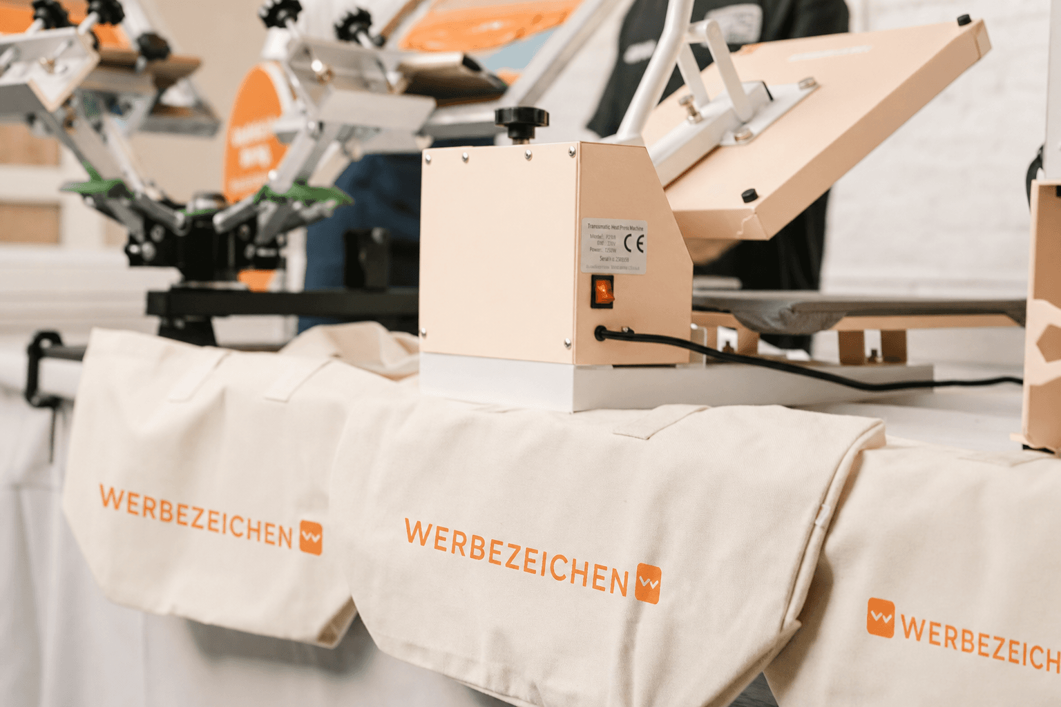 Header Siebdruck: Siebdruckmaschine und Werbezeichen Taschen
